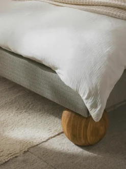 Gestoffeerd bed Rena met bolvormige poten van eikenhout